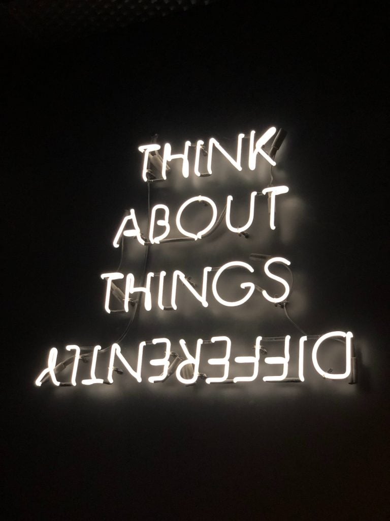 neon sign showing the words think about things differently