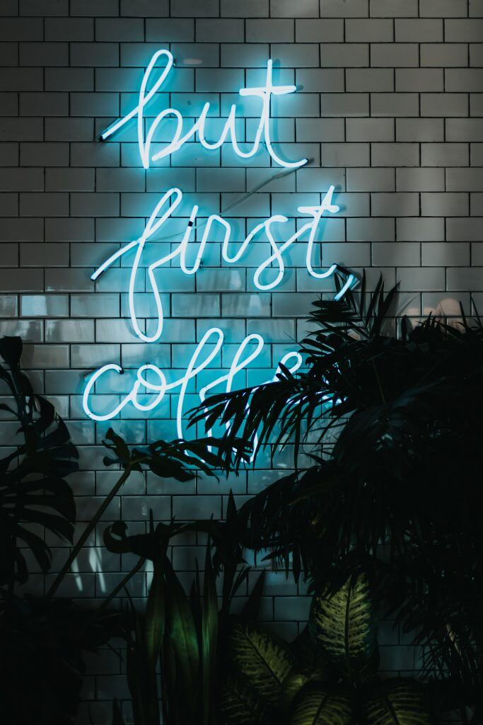 a neon sign saying but first coffee