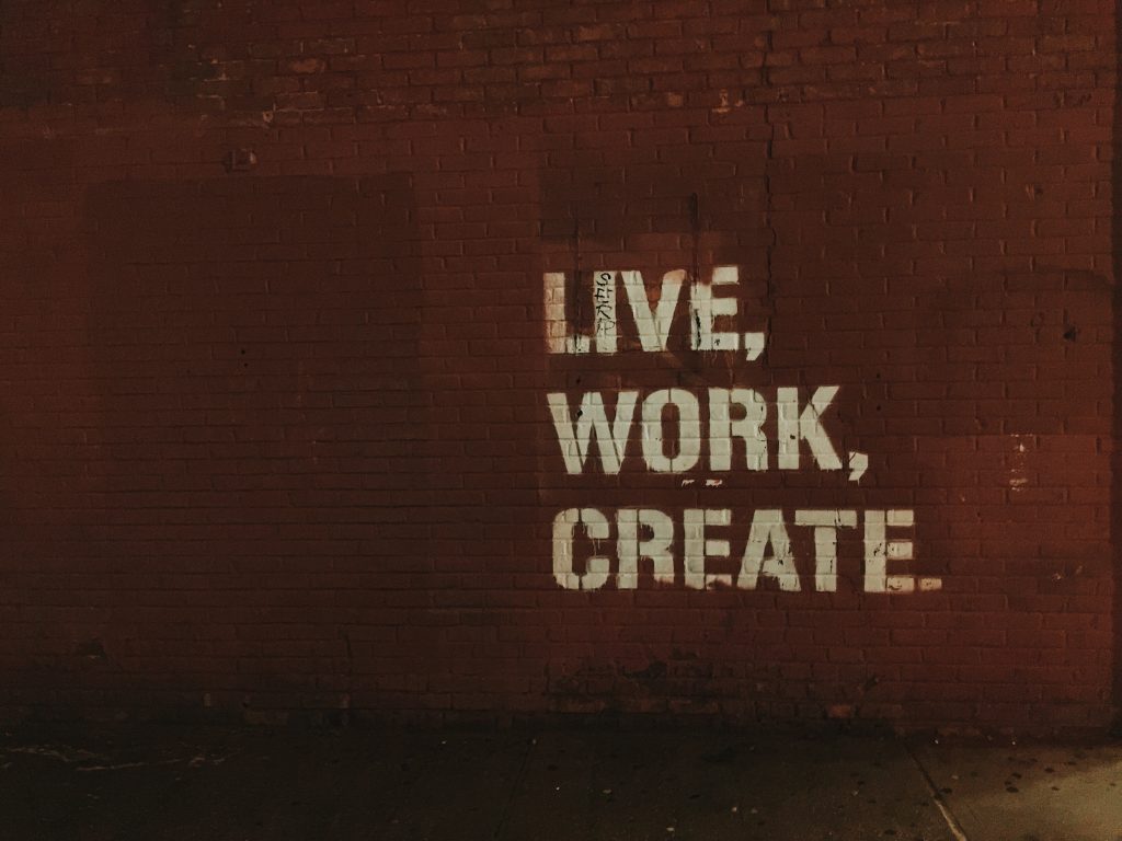 motivational message on a wall, live, work create