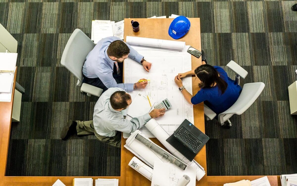 people sat at a desk and working together