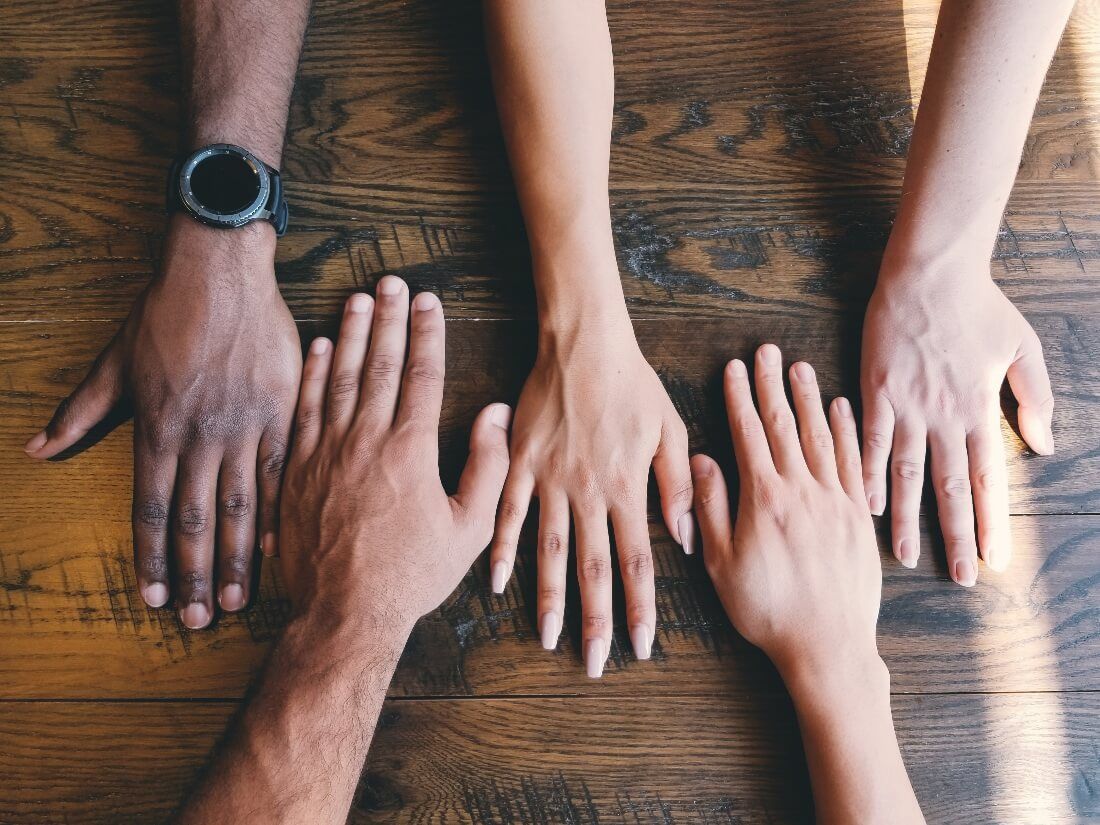 a diverse group of people with their hands on a table