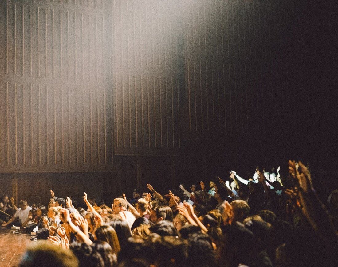 a group of people with their hands up for a question