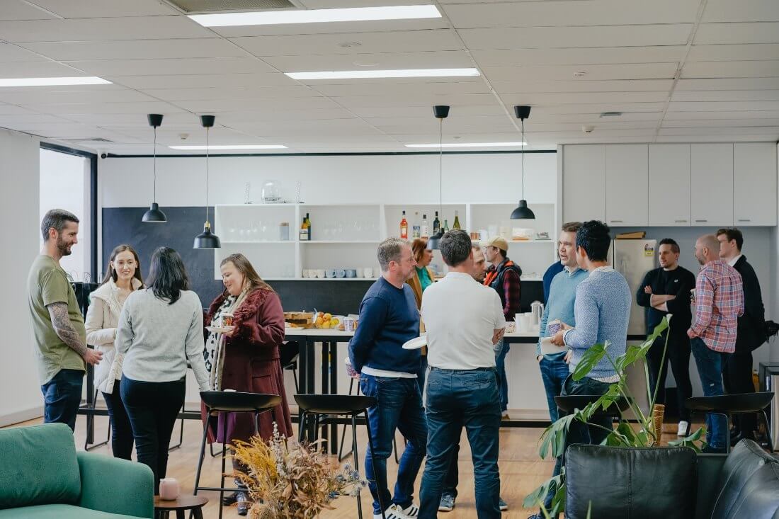 A group of people socialising in the office